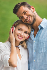 smiling woman in headphones and boyfriend