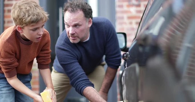Son helping Father wash car
