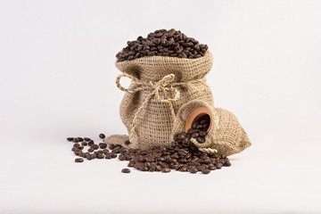 Roasted coffee beans in hemp sacks isolated on white background.