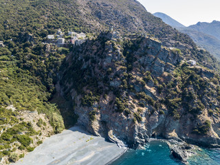 Vista aerea di Nonza e torre su una scogliera a picco sul mare. Spiaggia nera e mare. Penisola di...