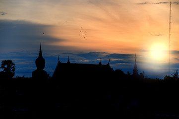 Naklejka premium Big Golden Buddha at Wat Sanawong is a temple in Ubon Ratchathani Thailand in the evening, where the sun is setting 