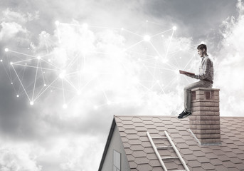 Man on brick roof reading book and concept of social connection