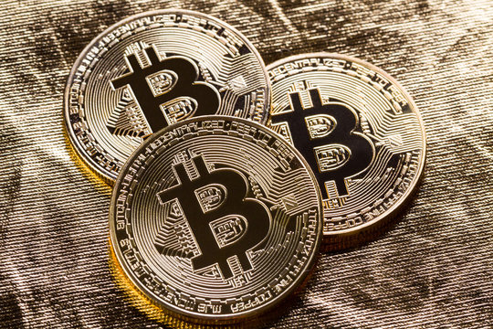 Bitcoin coins on gold colour background.