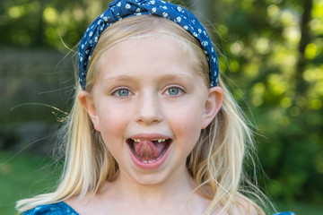 adorable school age girl smiling and showing front two teeth missing 