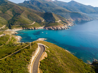 Vista aerea della costa della Corsica, strade serpeggianti e calette con mare cristallino. Penisola...
