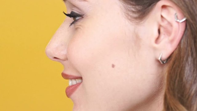 Close up side view of smiling woman posing in profile and looking away