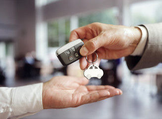 Fototapeta premium Sprzedaż samochodów kupujących nowy samochód przekazujący klucz