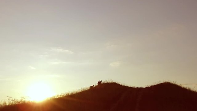 people group of tourists walking on top of a sunset silhouette mountain. slow video tourists travel people group go nature