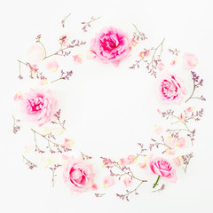 Floral round pattern made of pink roses, wild flowers and petals on white background. Flat lay, Top view.