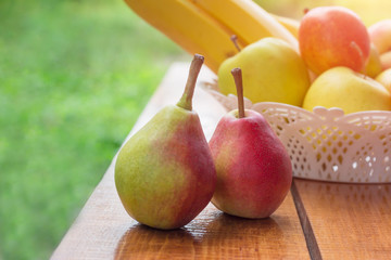 Healthy Organic Pears in the Basket on natural background. Two pears on the table. Copy space