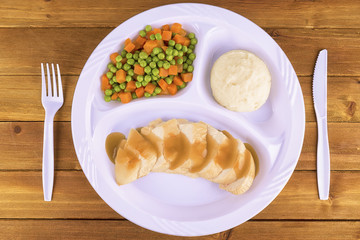Sliced chicken tv dinner on wooden background, top view.