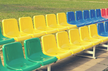 Obraz premium Multicolored benches for sports fans standing in two rows.