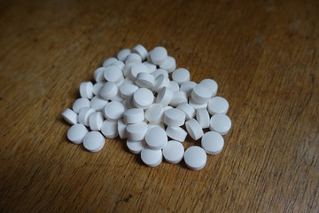 Fototapeta na wymiar Handful of pure white pills on wood