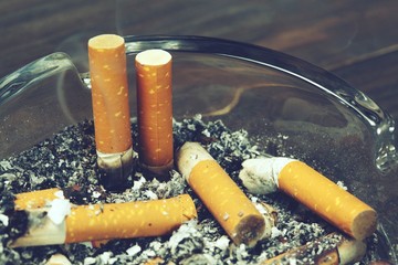Tobacco cigarettes ashtray and smoke.