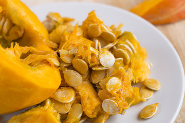 Pumpkin seeds and slices on the table. Close up.
