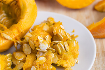 Pumpkin seeds and slices on the table. Close up.