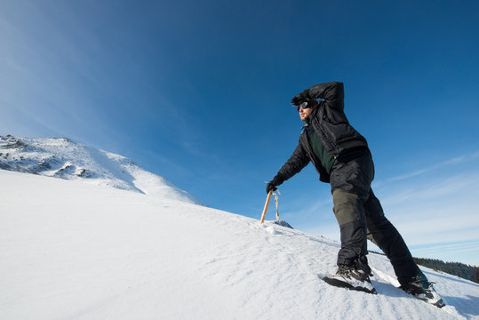 climber with an ice ax in the snowy mountains