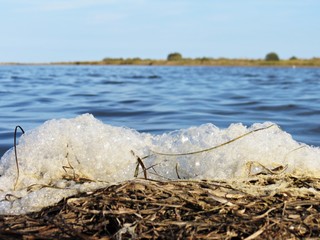 Espuma contaminante en la orilla de un río