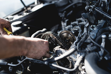 Obraz na płótnie Canvas Car service worker working on automobile engine repair