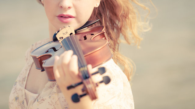 Woman playing violin on violin near beach