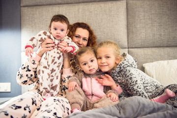 Portrait of a proud loving mother and happy little girl daughter sisters.Children wearing pajama.Laughing and having fun playing at home.Concept of love and happiness happy family.Family portrait.  