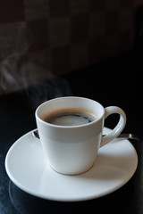 Coffee cup on black marble table in cafe