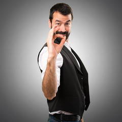 Cool man making OK sign on grey background