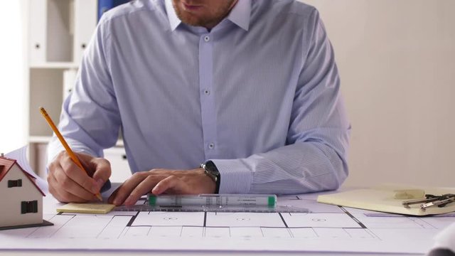 male architect with ruler measuring blueprint