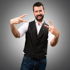Cool man making victory gesture on grey background