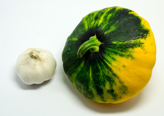 spotted squash on a white background and garlic
