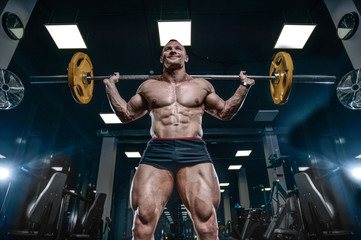 Obraz na płótnie Canvas Handsome model young man training legs in gym