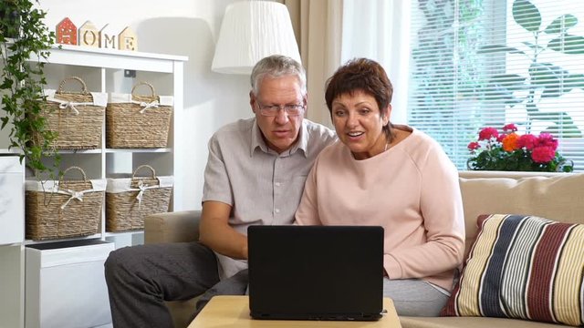 An Elderly Couple Communicates with Their Children using Laptop Video Call in the living room. Clow Motion