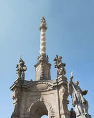 Fototapeta na wymiar Marian column, Lower square, Olomouc, Czech Republic / Czechia - monument and landmark with statues and sculptures is made in baroque style. Bottom view with blue sky as copy space