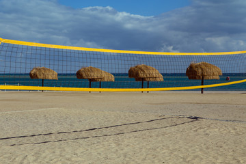 A volleyball net and thatched umbrellas on the beach. El Gouna. Egypt.
