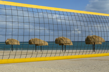 A volleyball net and thatched umbrellas on the beach. El Gouna. Egypt.