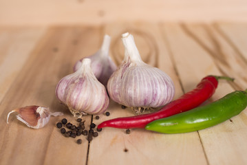 Garlic, parsley, chilli peppers, pepper peas on wooden rustic background