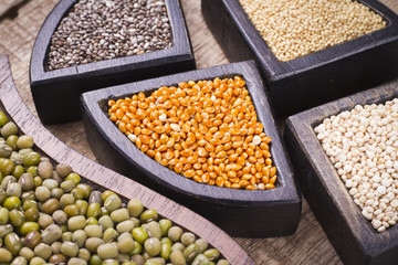 super food in wooden containers, amaranth, chia, quinoa and red millet