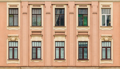 Fototapeta na wymiar Windows in a row on facade of apartment building