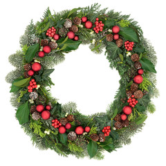 Fototapeta na wymiar Christmas wreath decoration with red baubles, holly, mistletoe, snow covered juniper fir, blue spruce, cedar and ivy leaves on white background.