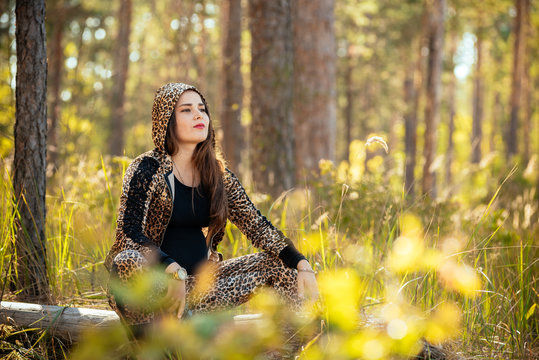 portrait of a beautiful pregnant young girl against a background of autumn forest. In fashionable clothes. Photo concept of pregnant women