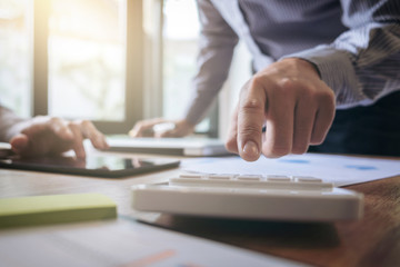 Business team two executive colleagues discussing and analysis working Financial investment on calculator with calculate on tablet Analyze business and market growth on financial document data graph