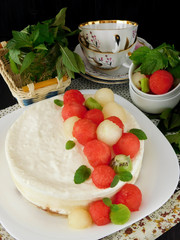 White cake decorated with watermelon, melon and kiwi ball-shaped pieces