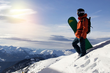 Small snowboarder on blue sky backdrop.