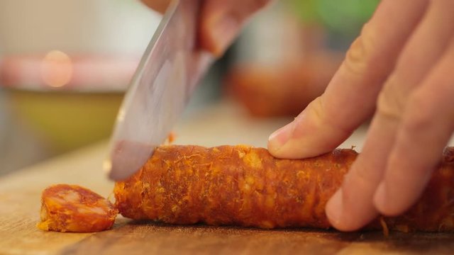 Preparing Food: cutting chorizo on a wooden board
