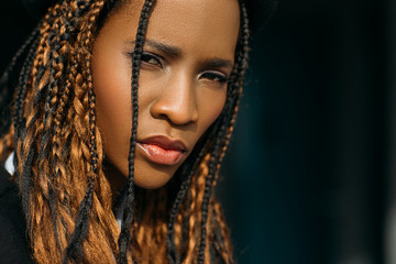 Sad African American woman. Distrustful emotion. Stress mood, incredulous look on black background,...