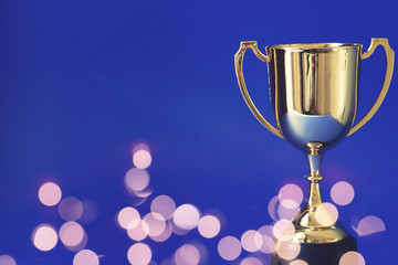 Gold winners trophy cup with bokeh blurred lights
