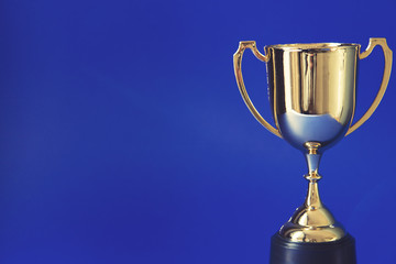 Gold winners trophy cup on a blue background