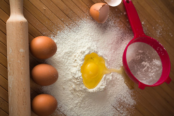 Flour and egg on a wooden background