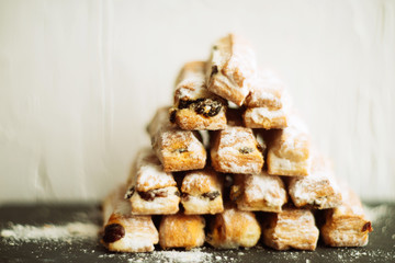 Strudel Apple and sugar powder. Biscuit from the puffed Test on the Gray Background. Dessert with Fruits.Copy space for Text. selective focus.