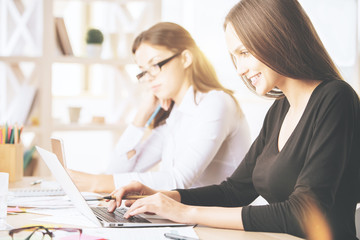 Gorgeous females using laptop at workplace